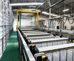 Aluminum surface treatment and anodizing production line with processing tanks, overhead equipment and clean industrial workshop environment.