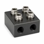 Hard-anodized CNC aluminum manifold block with four identical silver fittings installed on top ports.