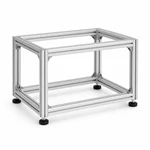 Modular machine frame assembled from silver T-slot aluminum profiles with leveling feet.